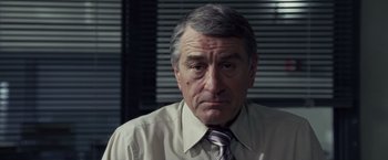 Movie still from “Stone” (2010), directed by John Curran – An older man wearing a shirt and a tie; Close Up shot, Over the shoulder angle