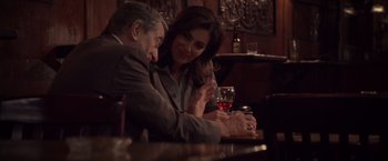 Movie still from “Stone” (2010), directed by John Curran – A man and a woman sitting in front of a glass of wine; Medium shot, Over the shoulder angle