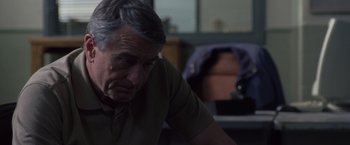 Movie still from “Stone” (2010), directed by John Curran – An older man sitting in front of a computer desk; Close Up shot, Over the shoulder angle