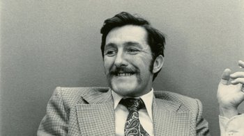 Movie still from “Stories We Tell” (2012), directed by Sarah Polley – An older man wearing a suit and a tie; Close Up shot, High angle