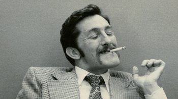 Movie still from “Stories We Tell” (2012), directed by Sarah Polley – A black and white photo of a man smoking a cigarette; Close Up shot, Low angle