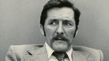 Movie still from “Stories We Tell” (2012), directed by Sarah Polley – An older man wearing a suit and a tie; Close Up shot, Low angle