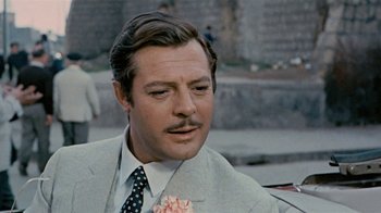 Movie still from “Stories We Tell” (2012), directed by Sarah Polley – A person wearing a suit and tie; Close Up shot, Over the shoulder angle