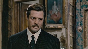 Movie still from “Stories We Tell” (2012), directed by Sarah Polley – A person wearing a suit and tie; Close Up shot, Low angle