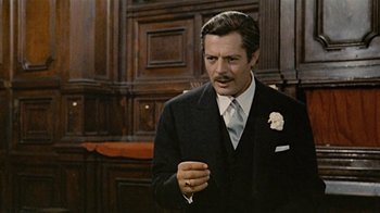 Movie still from “Stories We Tell” (2012), directed by Sarah Polley – A person wearing a suit and tie; Close Up shot, Over the shoulder angle