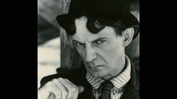 Movie still from “Stories We Tell” (2012), directed by Sarah Polley – A man wearing a hat and a tie; Close Up shot, Low angle