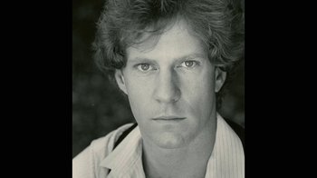 Movie still from “Stories We Tell” (2012), directed by Sarah Polley – Black and white photograph of a man in a white shirt; Close Up shot, High angle