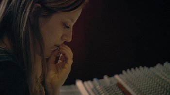 Movie still from “Stories We Tell” (2012), directed by Sarah Polley – A woman sitting in front of a computer keyboard; Close Up shot, High angle