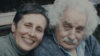 Movie still from “Stories We Tell” (2012), directed by Sarah Polley – An older man and a younger woman smiling for the camera; Close Up shot, Low angle