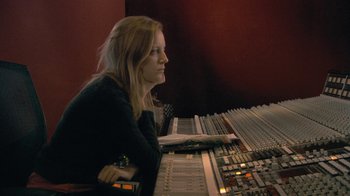Movie still from “Stories We Tell” (2012), directed by Sarah Polley – A woman sitting in front of a sound board; Medium shot, High angle
