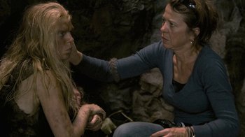 Movie still from “Stories We Tell” (2012), directed by Sarah Polley – A woman sitting on the ground with another woman touching her face; Close Up shot, Over the shoulder angle