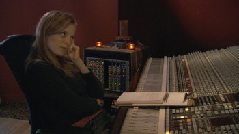 Movie still from “Stories We Tell” (2012), directed by Sarah Polley – A woman sitting in front of a sound board; Medium shot, High angle