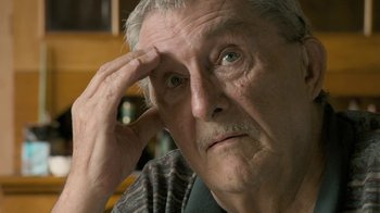 Movie still from “Stories We Tell” (2012), directed by Sarah Polley – An older man is looking into the distance; Close Up shot, Over the shoulder angle
