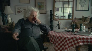 Movie still from “Stories We Tell” (2012), directed by Sarah Polley – An older man drinking a cup of coffee in a room; Medium shot, Over the shoulder angle