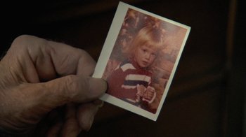 Movie still from “Stories We Tell” (2012), directed by Sarah Polley – A person holding an old photo of a young girl; Extreme Close Up shot, Overhead angle