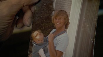 Movie still from “Stories We Tell” (2012), directed by Sarah Polley – An old photo of a woman holding a baby in a sling; Extreme Close Up shot, High angle
