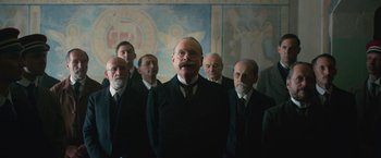 Movie still from “All Quiet on the Western Front” (2022), directed by Edward Berger – A group of men standing in front of a painting; Medium shot, Low angle