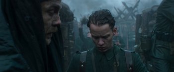 Movie still from “All Quiet on the Western Front” (2022), directed by Edward Berger – A man in a green uniform looking at another man in a green uniform; Close Up shot, Low angle