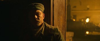 Movie still from “All Quiet on the Western Front” (2022), directed by Edward Berger – A man wearing a hat and a uniform; Close Up shot, Low angle