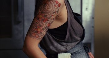Movie still from “Stranger Than Fiction” (2006), directed by Marc Forster – A woman with a tattoo on her right arm; Extreme Close Up shot, Overhead angle