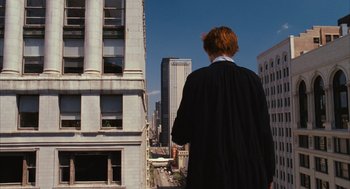 Movie still from “Stranger Than Fiction” (2006), directed by Marc Forster – A man in a black robe looking out over a city; Wide shot, Low angle
