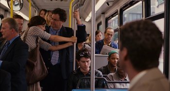 Movie still from “Stranger Than Fiction” (2006), directed by Marc Forster – A group of people riding on a train; Medium shot, Over the shoulder angle