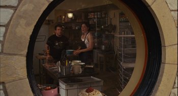 Movie still from “Stranger Than Fiction” (2006), directed by Marc Forster – A man and a woman standing in a kitchen; Medium shot, Over the shoulder angle
