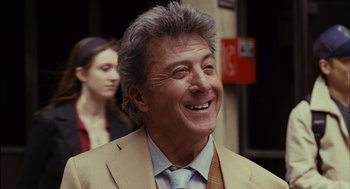 Movie still from “Stranger Than Fiction” (2006), directed by Marc Forster – An older man wearing a suit and smiling; Close Up shot, Over the shoulder angle
