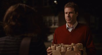 Movie still from “Stranger Than Fiction” (2006), directed by Marc Forster – A man in a red sweater holding a box of food; Medium shot, Over the shoulder angle