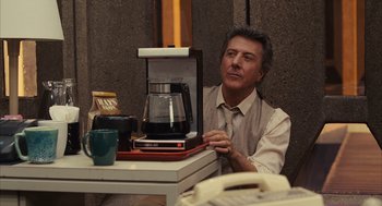 Movie still from “Stranger Than Fiction” (2006), directed by Marc Forster – A man sitting in front of a coffee maker; Medium shot, Over the shoulder angle