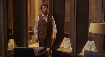 Movie still from “Stranger Than Fiction” (2006), directed by Marc Forster – A man standing in front of a window in a room; Medium shot, Over the shoulder angle