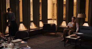 Movie still from “Stranger Than Fiction” (2006), directed by Marc Forster – A man sitting in a chair in front of a window; Wide shot, High angle