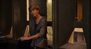 Movie still from “Stranger Than Fiction” (2006), directed by Marc Forster – A woman sitting in front of a window with a purse; Medium shot, High angle
