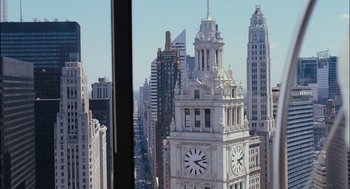 Movie still from “Stranger Than Fiction” (2006), directed by Marc Forster – A view of a large clock tower in the middle of a city; Extreme Wide shot, High angle