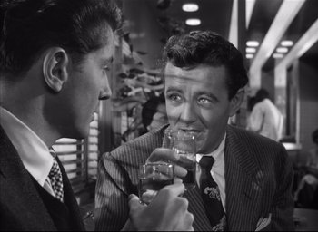 Movie still from “Strangers on a Train” (1951), directed by Alfred Hitchcock – Two men in suits are drinking a glass of beer; Close Up shot, Over the shoulder angle