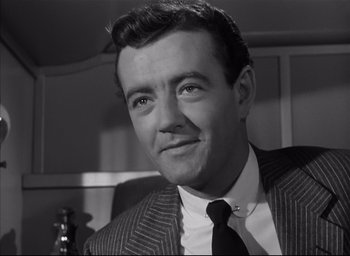 Movie still from “Strangers on a Train” (1951), directed by Alfred Hitchcock – Black and white photograph of a man wearing a suit and tie; Close Up shot, Low angle