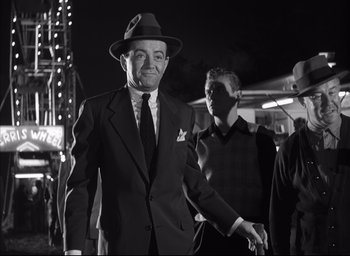 Movie still from “Strangers on a Train” (1951), directed by Alfred Hitchcock – An older man wearing a suit and a hat; Medium shot, Low angle