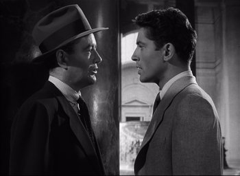 Movie still from “Strangers on a Train” (1951), directed by Alfred Hitchcock – Two men in suits and hats facing each other; Close Up shot, Over the shoulder angle