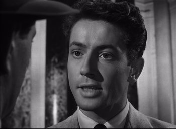 Movie still from “Strangers on a Train” (1951), directed by Alfred Hitchcock – A black and white photo of a man in a suit and tie; Close Up shot, Over the shoulder angle