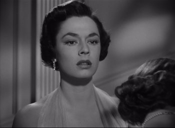 Movie still from “Strangers on a Train” (1951), directed by Alfred Hitchcock – A black - and - white photo of a woman in a dress; Close Up shot, Low angle