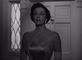 Movie still from “Strangers on a Train” (1951), directed by Alfred Hitchcock – A black - and - white photo of a woman in a dress; Close Up shot, Low angle