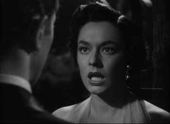 Movie still from “Strangers on a Train” (1951), directed by Alfred Hitchcock – An old black and white photo of a woman looking angry; Close Up shot, Over the shoulder angle