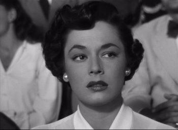 Movie still from “Strangers on a Train” (1951), directed by Alfred Hitchcock – An old black and white photo of a woman; Close Up shot, High angle