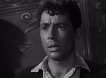 Movie still from “Strangers on a Train” (1951), directed by Alfred Hitchcock – Black and white photograph of a man looking at the camera; Close Up shot, Low angle