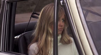 Movie still from “Straw Dogs” (1971), directed by Sam Peckinpah – A woman sitting in the back seat of a car; Close Up shot, Low angle