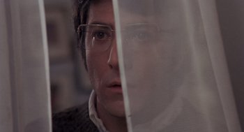 Movie still from “Straw Dogs” (1971), directed by Sam Peckinpah – A person wearing glasses and looking at the camera; Close Up shot, Low angle