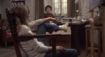 Movie still from “Straw Dogs” (1971), directed by Sam Peckinpah – A man and a woman sitting on a chair in a room; Medium shot, Over the shoulder angle