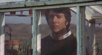 Movie still from “Straw Dogs” (1971), directed by Sam Peckinpah – A man looking out of a window in a sweater; Close Up shot, Over the shoulder angle