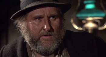 Movie still from “Straw Dogs” (1971), directed by Sam Peckinpah – An old man with a beard wearing a hat; Close Up shot, Low angle