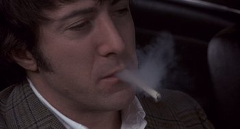 Movie still from “Straw Dogs” (1971), directed by Sam Peckinpah – A person smoking a cigarette; Close Up shot, Low angle